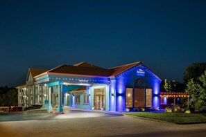 A hotel with a blue exterior, a covered entrance, and a sign indicating a clearance of 12 inches. - Baymont by Wyndham Branson Thousand Hills (Branson)