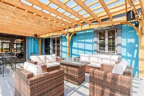 An outdoor seating area with wicker furniture and a wooden pergola. - Baymont by Wyndham Branson Thousand Hills (Branson)