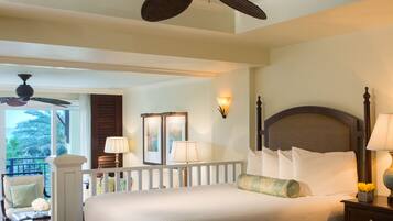 A hotel room with a bed, two bedside lamps, a ceiling fan, a balcony with a chair, and a view of palm trees.