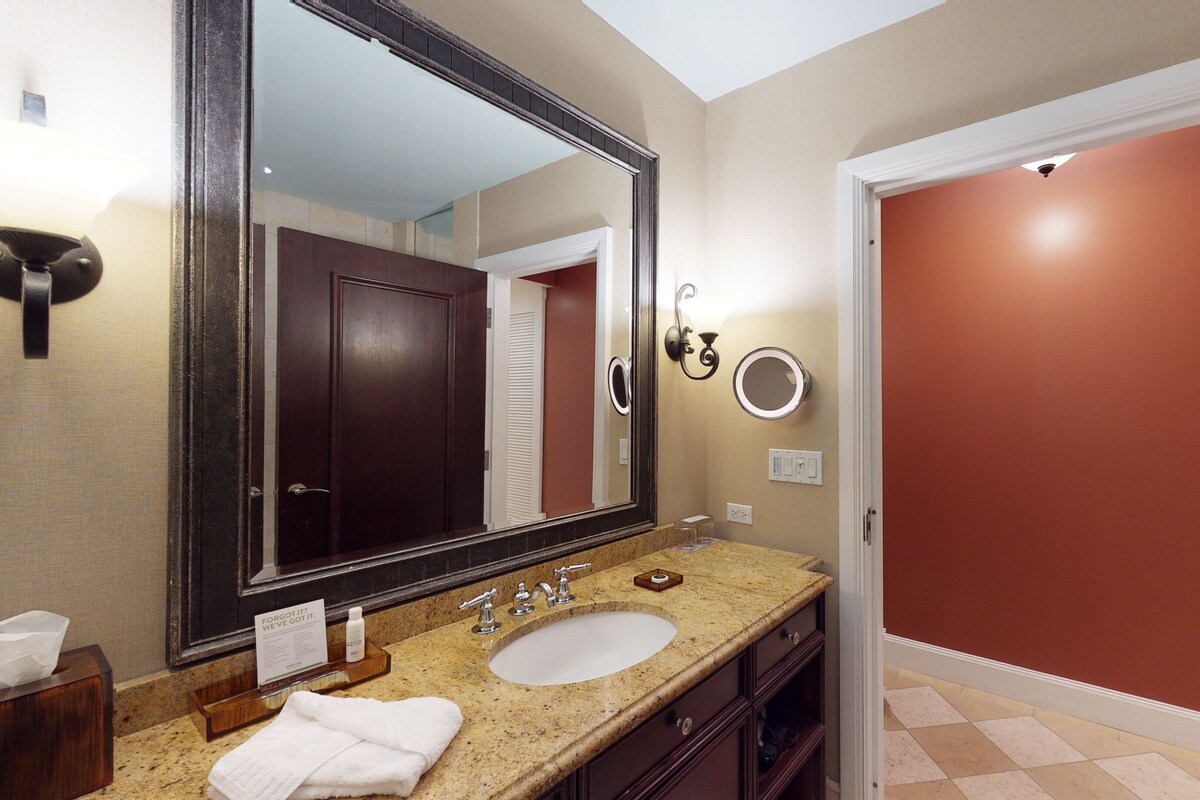 Une salle de bain avec un grand miroir, un lavabo et un meuble-lavabo.