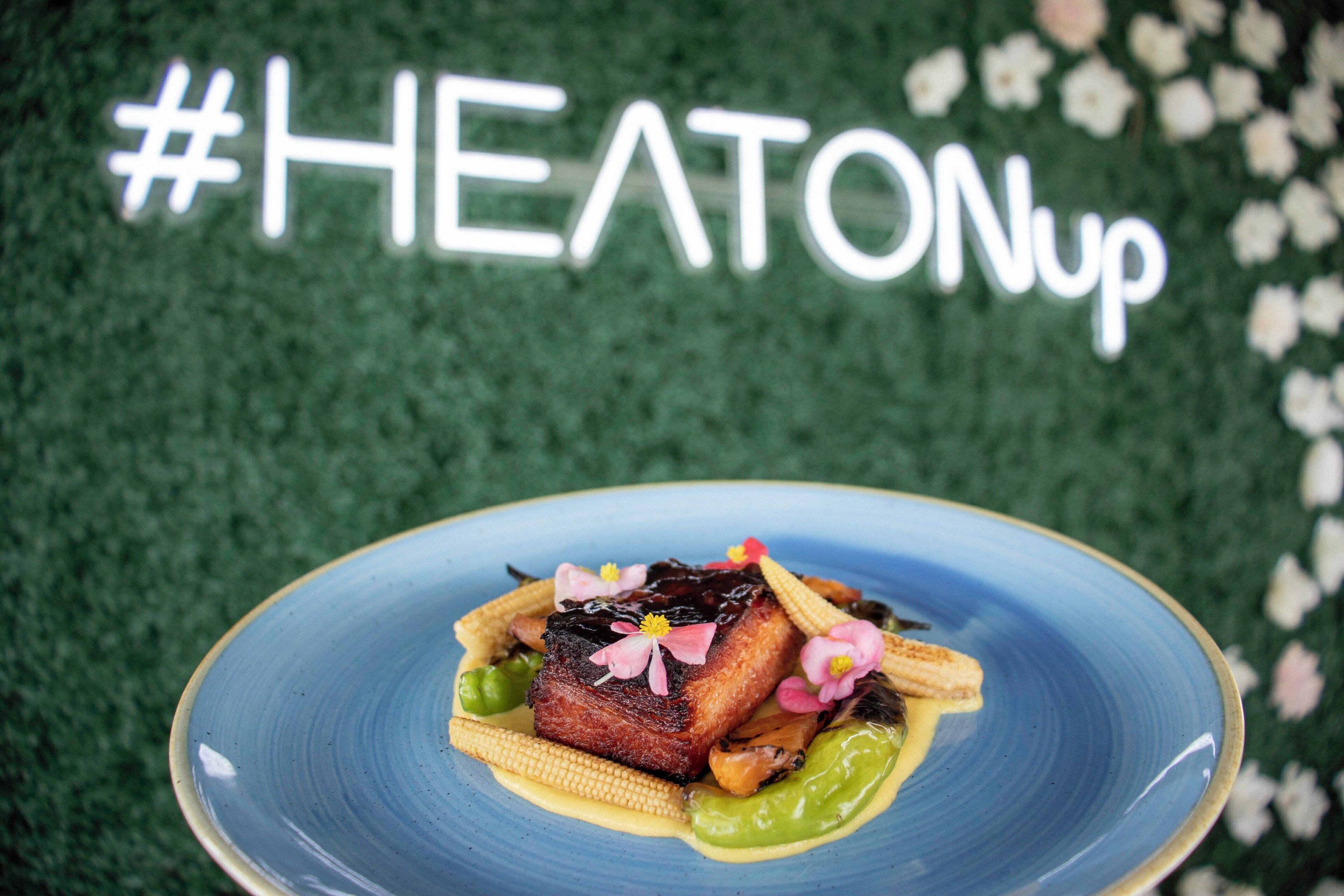 A blue plate with a dish of food, including meat, corn, and vegetables, with a hashtag sign in the background.