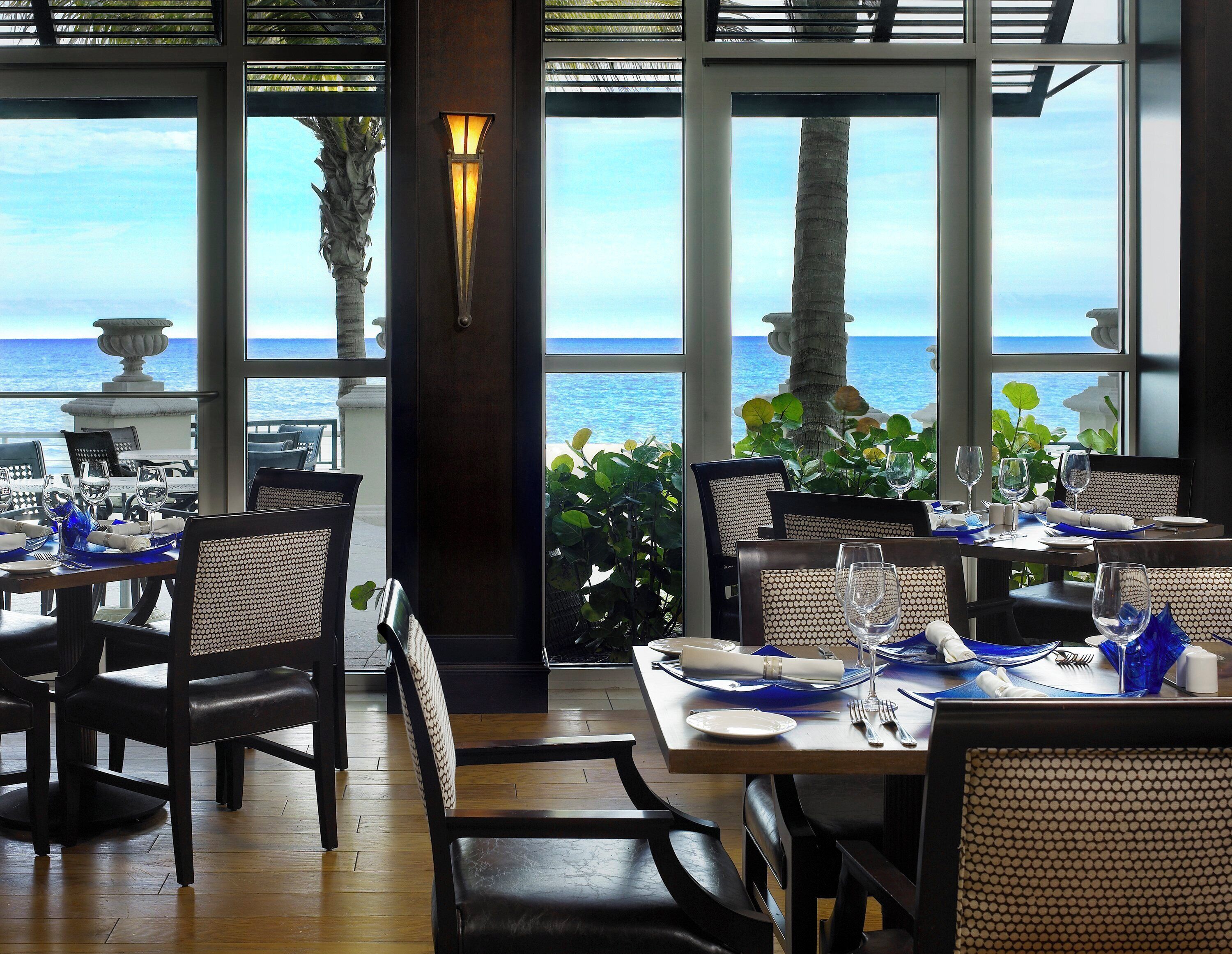 Un restaurante con mesas dispuestas para comer, con vistas a un cuerpo de agua.