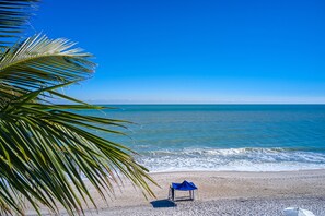 On the beach, white sand, beach cabanas, sun-loungers
