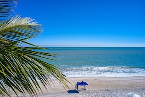 On the beach, white sand, beach cabanas, sun loungers