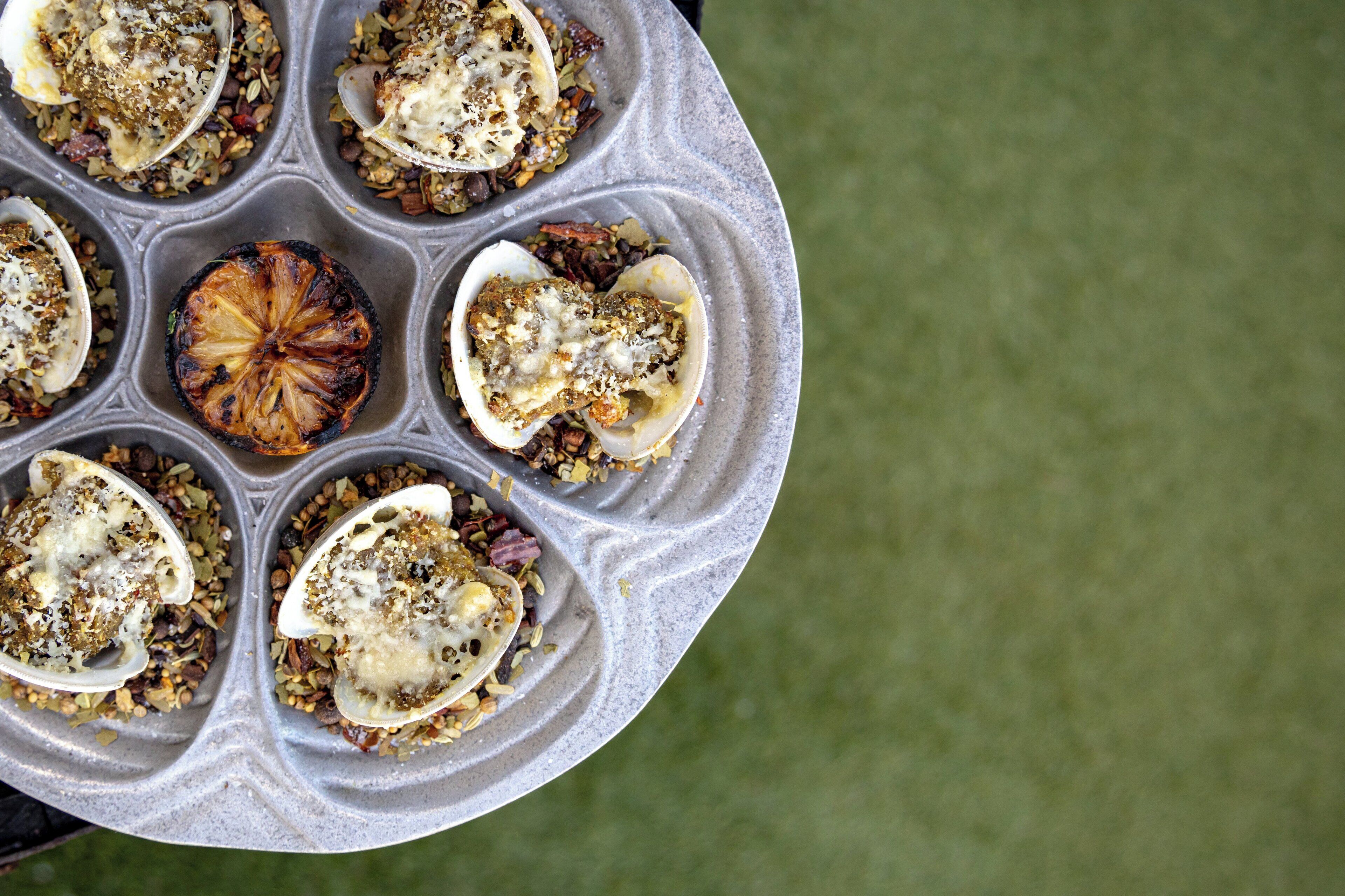 Un moule à muffins contenant six viennoiseries, chacune garnie d’un morceau de fruit et d’une garniture.