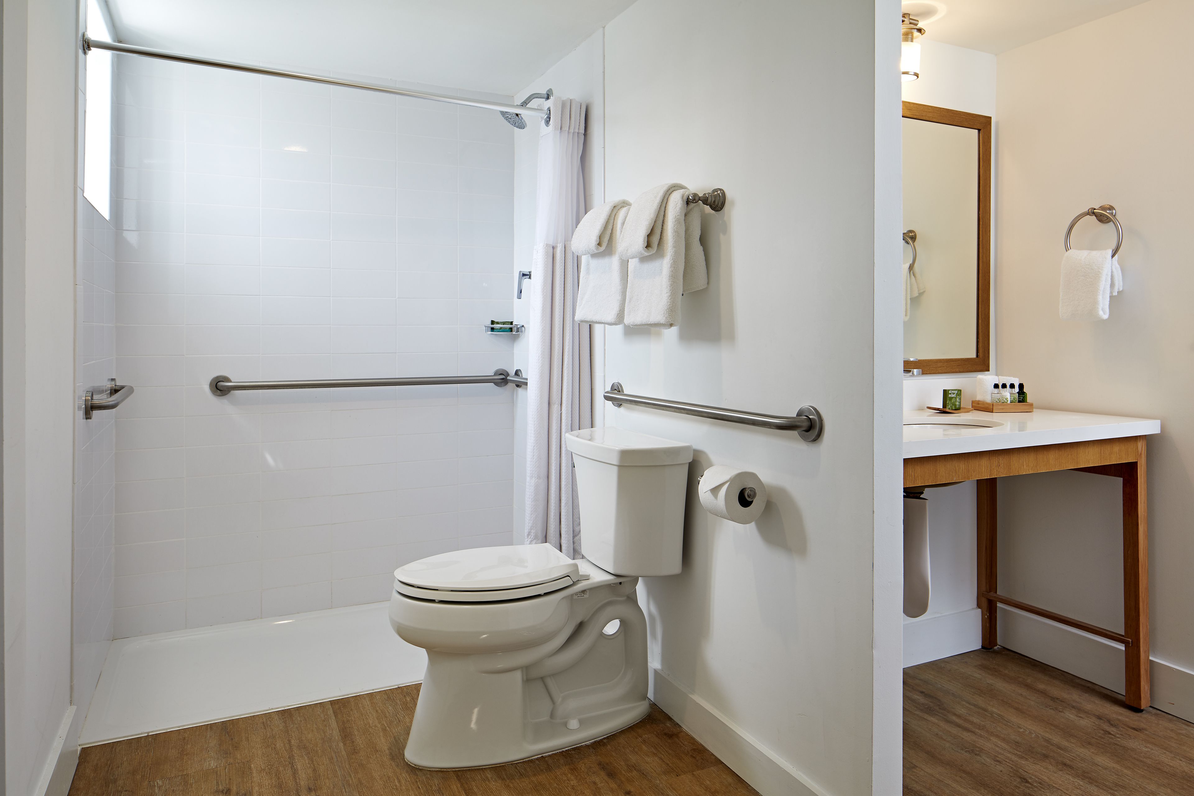 A modern bathroom with a walk-in shower, a toilet, and a sink with a mirror.