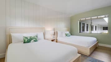 A hotel room with two beds, a large mirror, and a view of the corridor.
