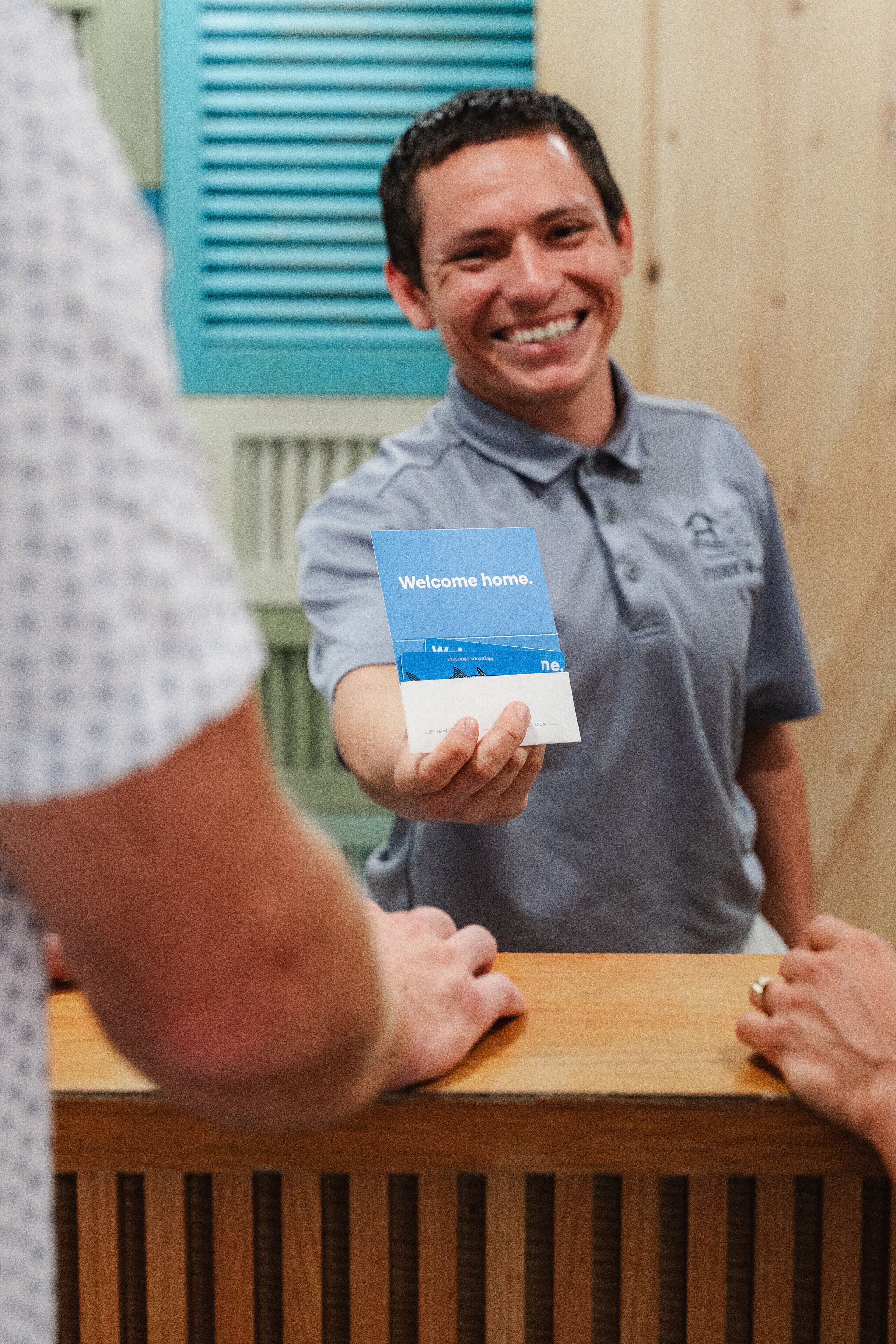 A person holding a welcome card at a reception desk.