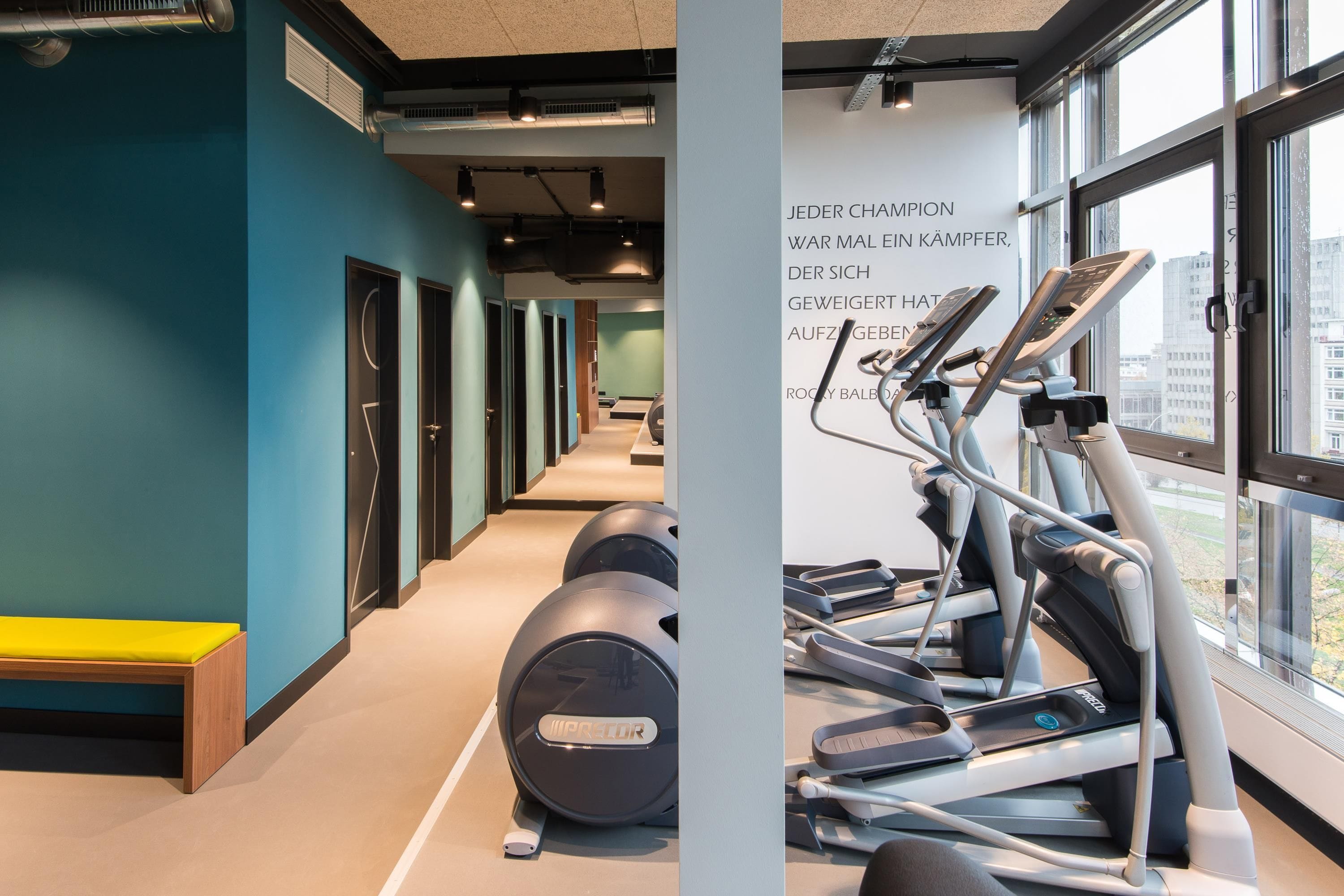 Une salle de sport équipée de matériel d’exercice, d’un banc et d’un mur avec du texte.