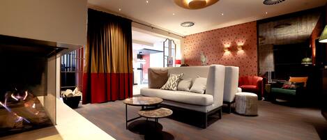 A modern living room with a sofa, a coffee table, and a fireplace.