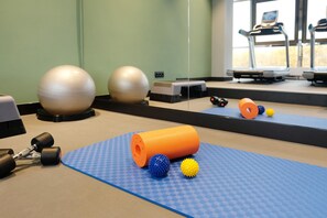 A gym with exercise equipment, including a treadmill, exercise balls, and dumbbells. - Best Western Plus Hotel St. Raphael (Hamburg)