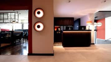 A modern interior with a bar area, seating, and a reception desk.
