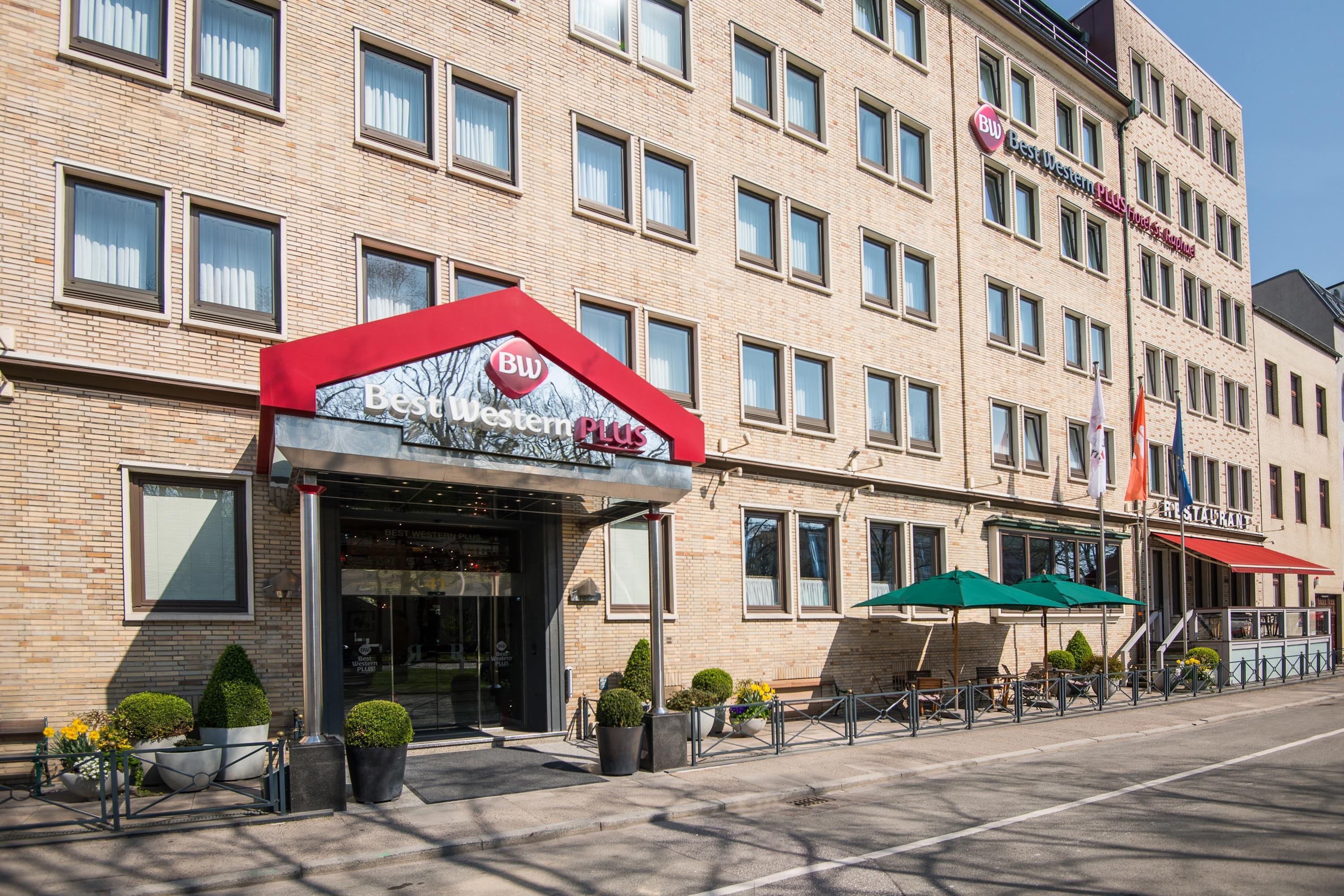 A hotel with a prominent 'Best Western Plus' sign, multiple windows, and a restaurant on the ground floor.