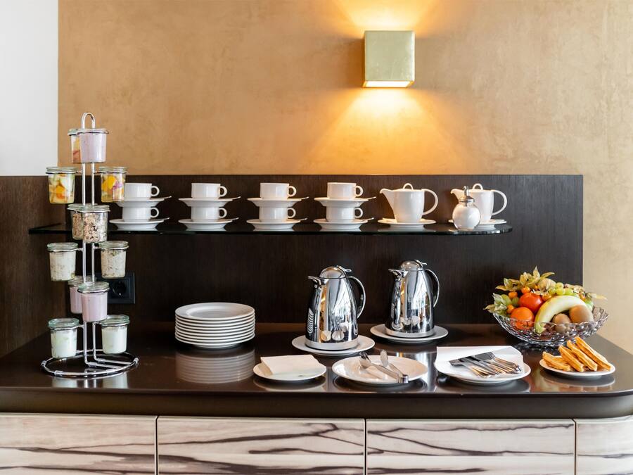 A breakfast buffet setup with various food items and tableware.
