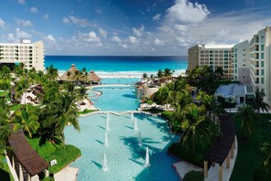 A resort with a central pool, palm trees, and a view of the ocean. - The Westin Lagunamar Ocean Resort Villas & Spa, Cancun (Cancun)