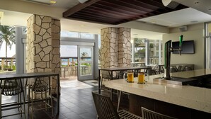 A modern bar area with stone pillars, a bar counter, and seating.