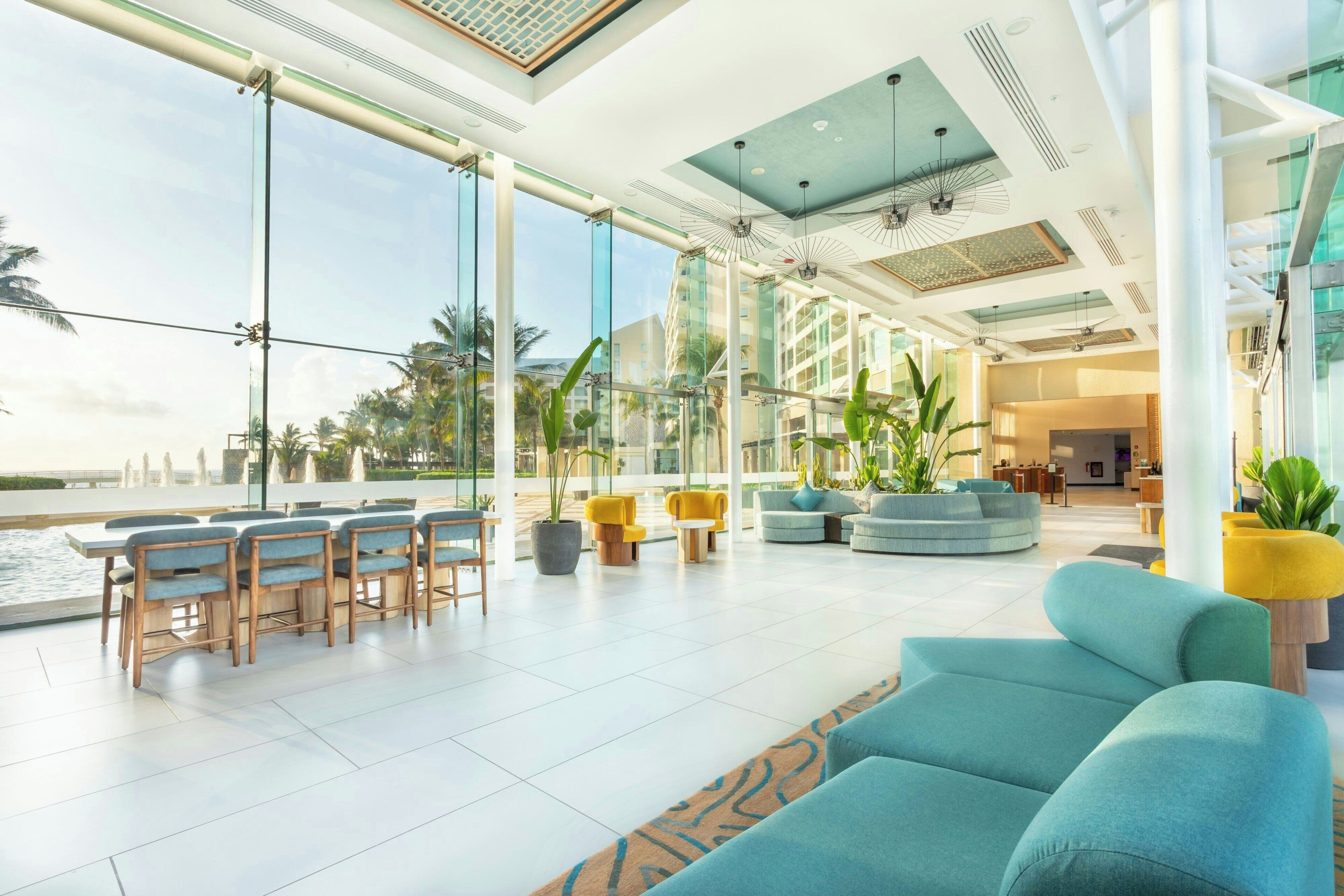 Un vaste espace intérieur avec vue sur la piscine, doté de meubles modernes et de grandes fenêtres.