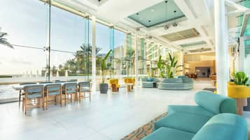 Un vaste espace intérieur avec vue sur la piscine, doté de meubles modernes et de grandes fenêtres.
