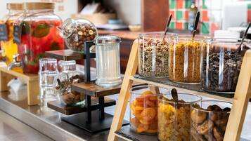 A food display with various jars of nuts, dried fruits, and granola.