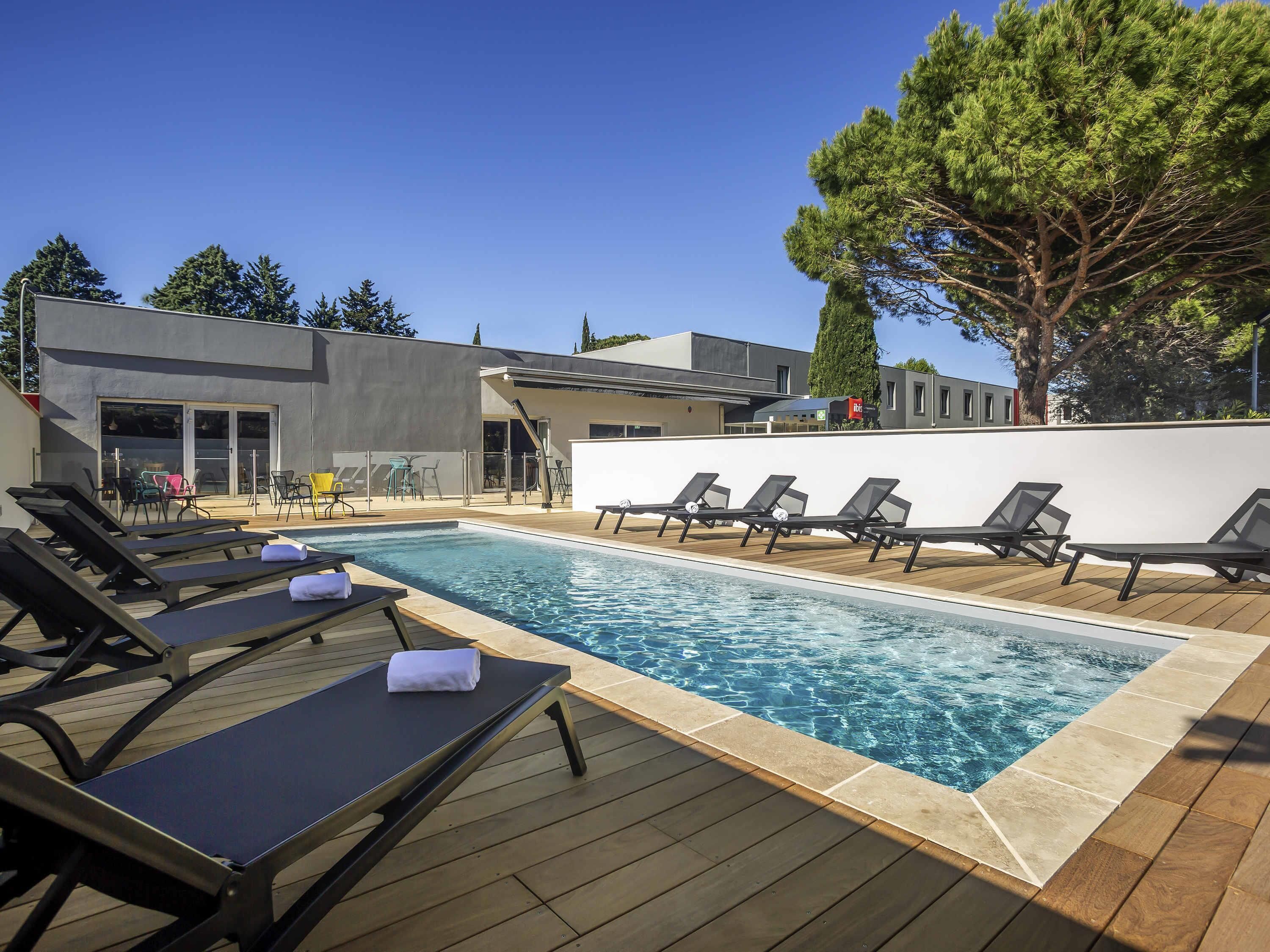 Una piscina al aire libre de temporada, sillones reclinables de piscina