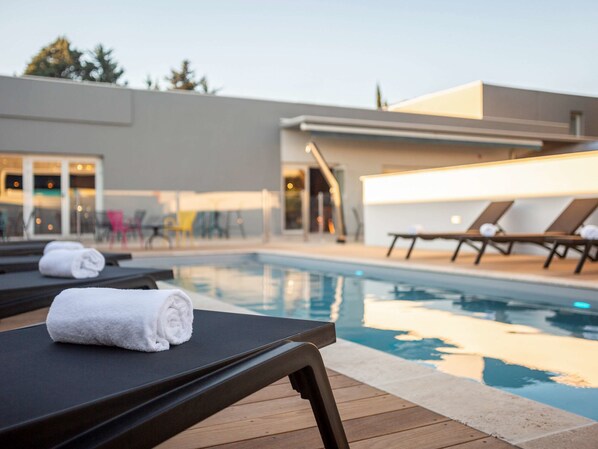 Piscine extérieure en saison, chaises longues