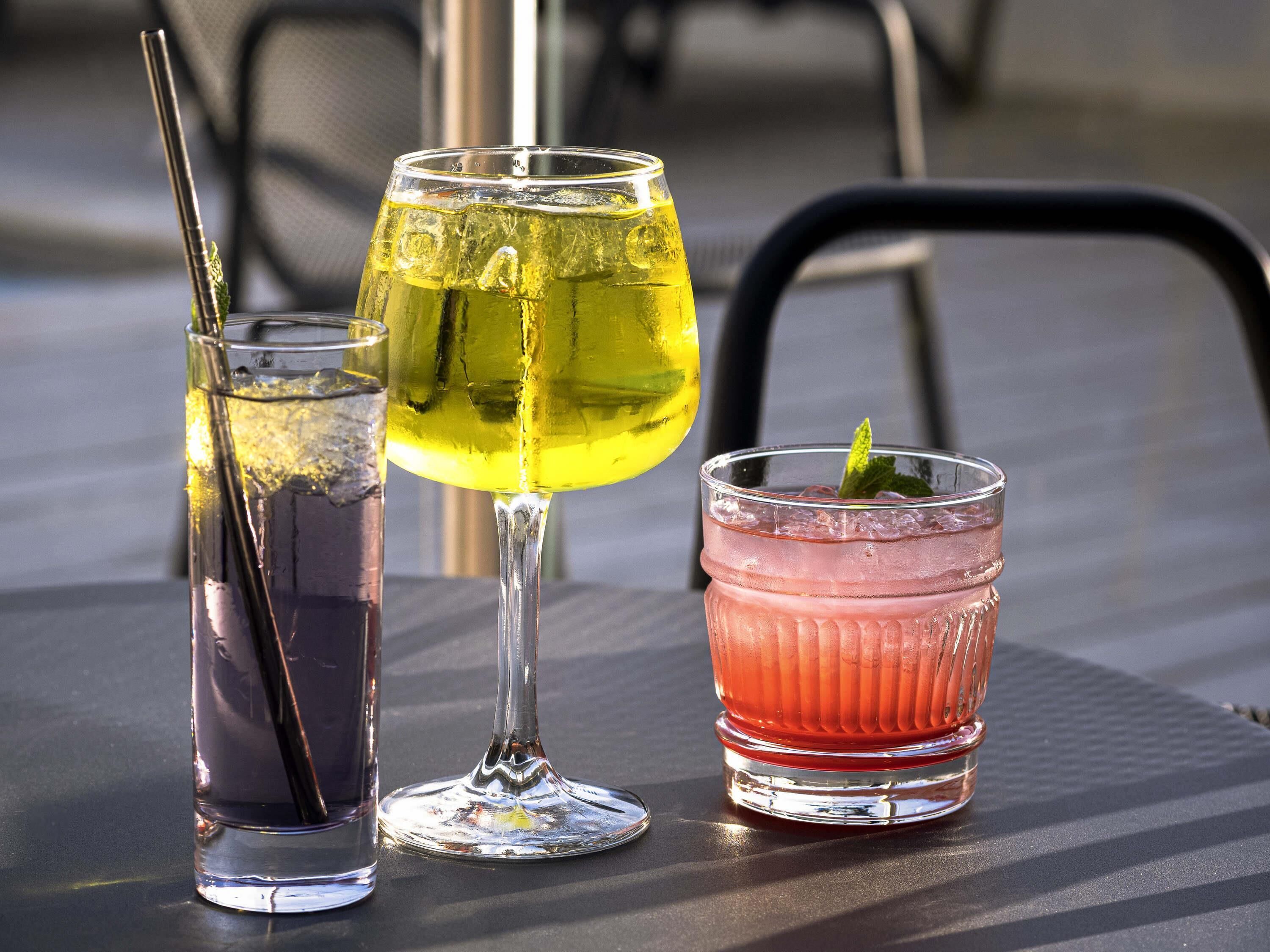 Three glasses of beverages on a table.