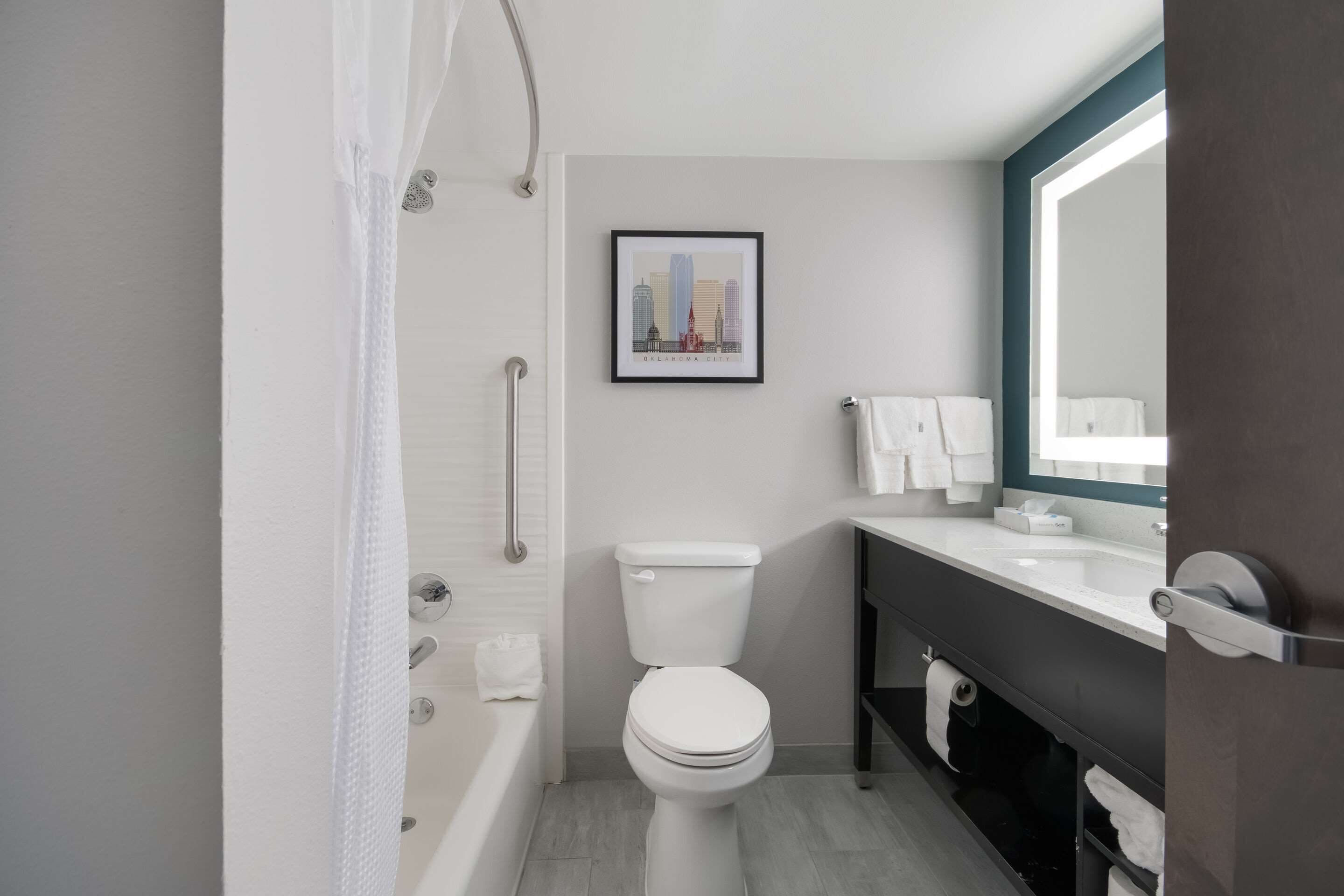 A modern bathroom with a toilet, sink, and shower.