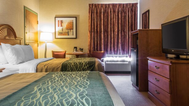 A hotel room with a bed, a desk, a television, and a wardrobe. - Quality Inn & Suites Mansfield (Mansfield)
