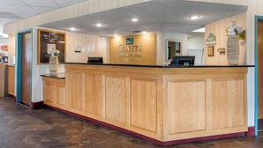 A reception desk with a wooden finish, a sign reading "QUALITY INN & LODGES", and a "MANAGER ON DUTY" sign. - Quality Inn & Suites Mansfield (Mansfield)