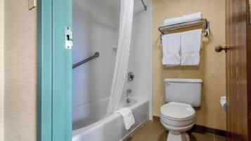 Un baño con bañera, inodoro y perchero para toallas.