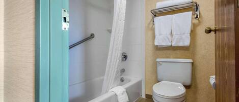 Un baño con bañera, inodoro y perchero para toallas.