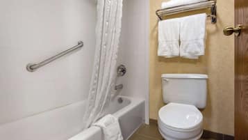 A bathroom with a bathtub, toilet, and towel rack.