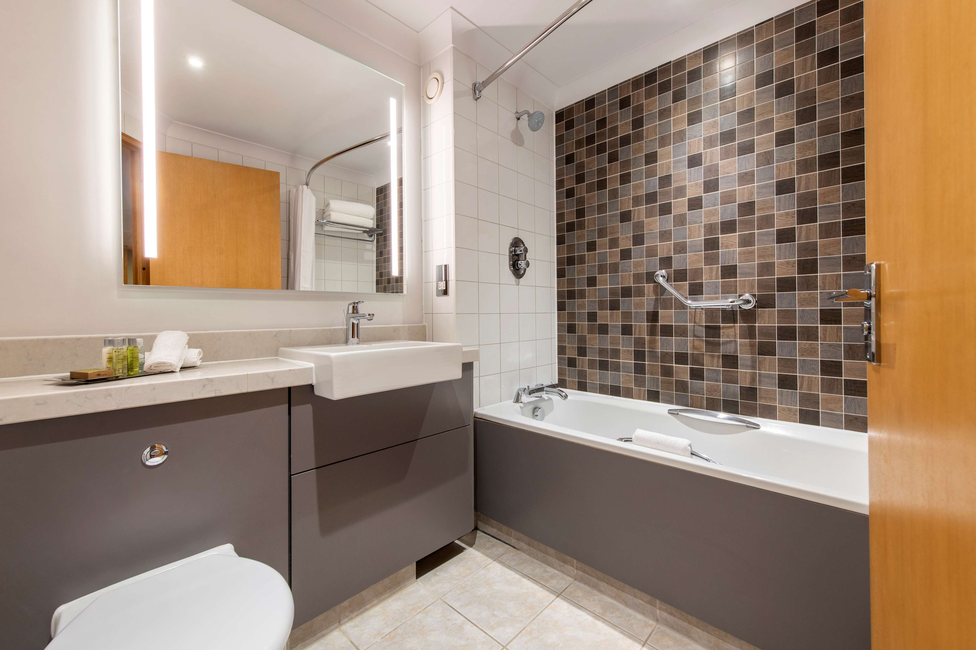 Un baño moderno con bañera, lavamanos y retrete.