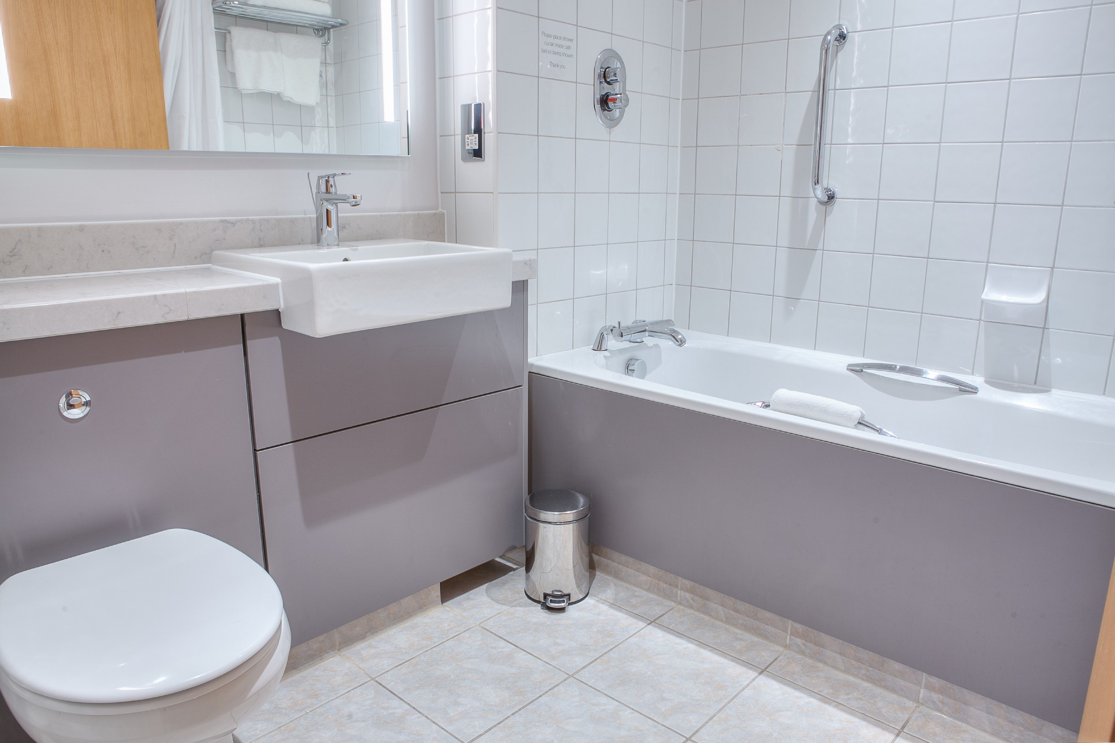 A modern bathroom with a toilet, sink, and bathtub.