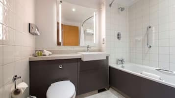 Une salle de bain moderne équipée de toilettes, d’un lavabo, d’un meuble-lavabo et d’une baignoire.