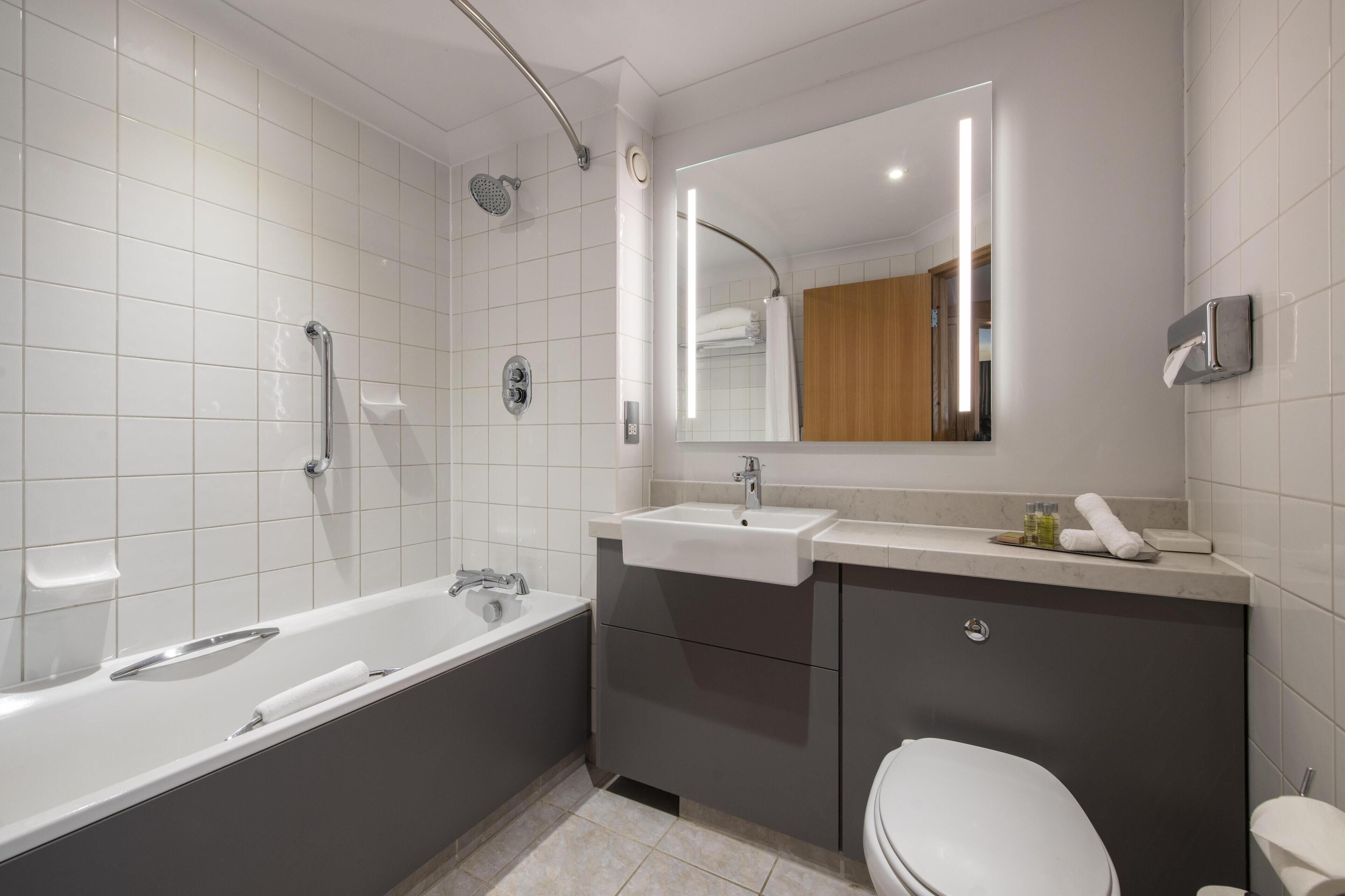 A modern bathroom with a bathtub, a sink, and a toilet.