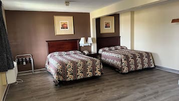 Une chambre d’hôtel avec deux lits, une tête de lit en bois, une table de chevet avec une lampe et un climatiseur fixé au mur.