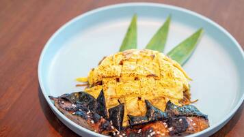 Une assiette avec du poisson grillé et un œuf grillé, le tout servi sur une assiette bleue.
