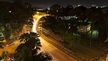 An aerial view of a city intersection at night with visible traffic lights and streetlights.