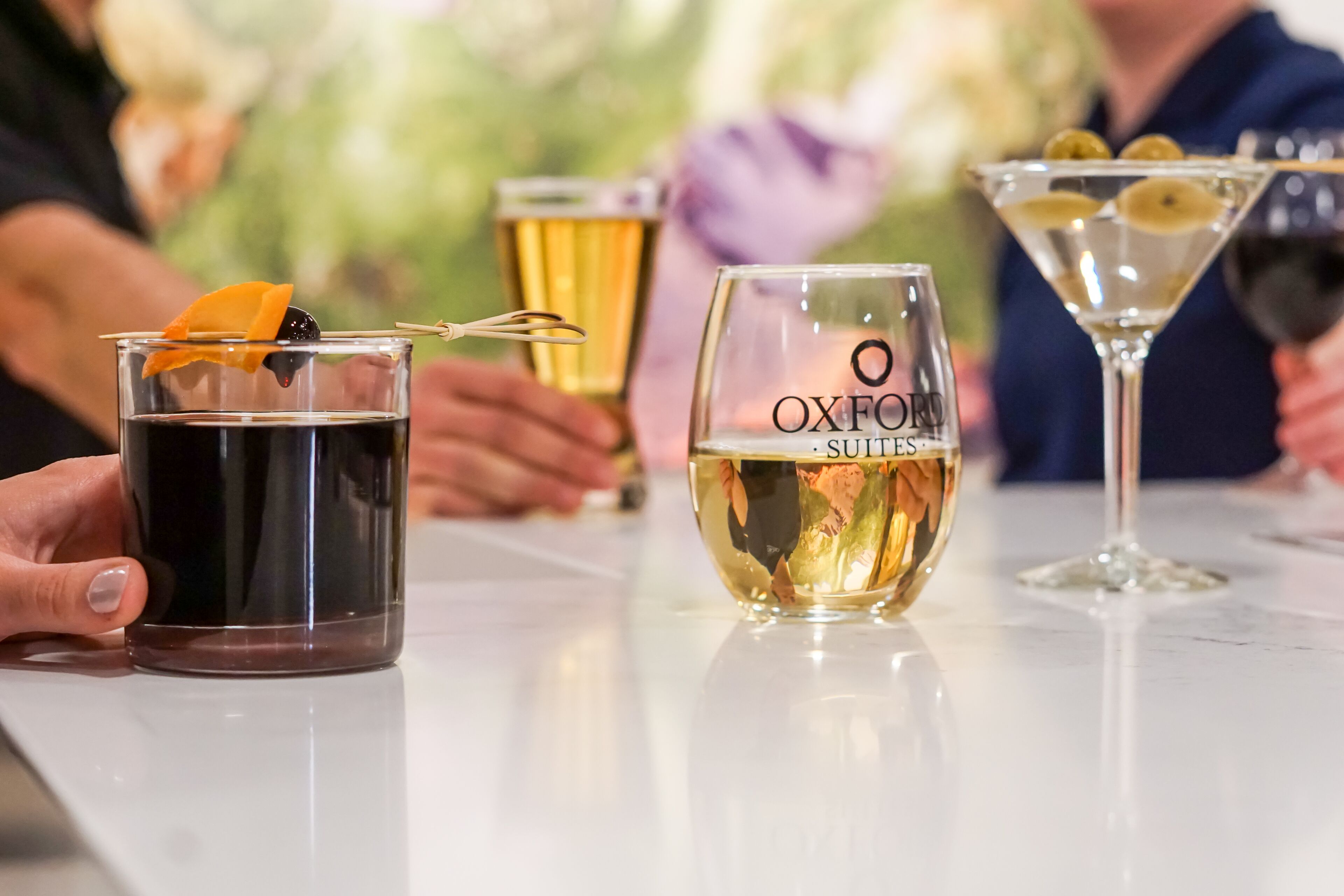 Un bar con diferentes vasos de bebidas, incluyendo un martini y un vaso con una rodaja de limón.