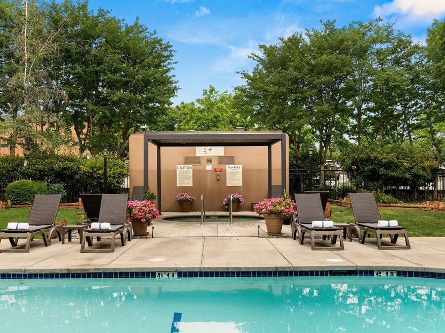 A swimming pool area with lounge chairs and a caution sign.