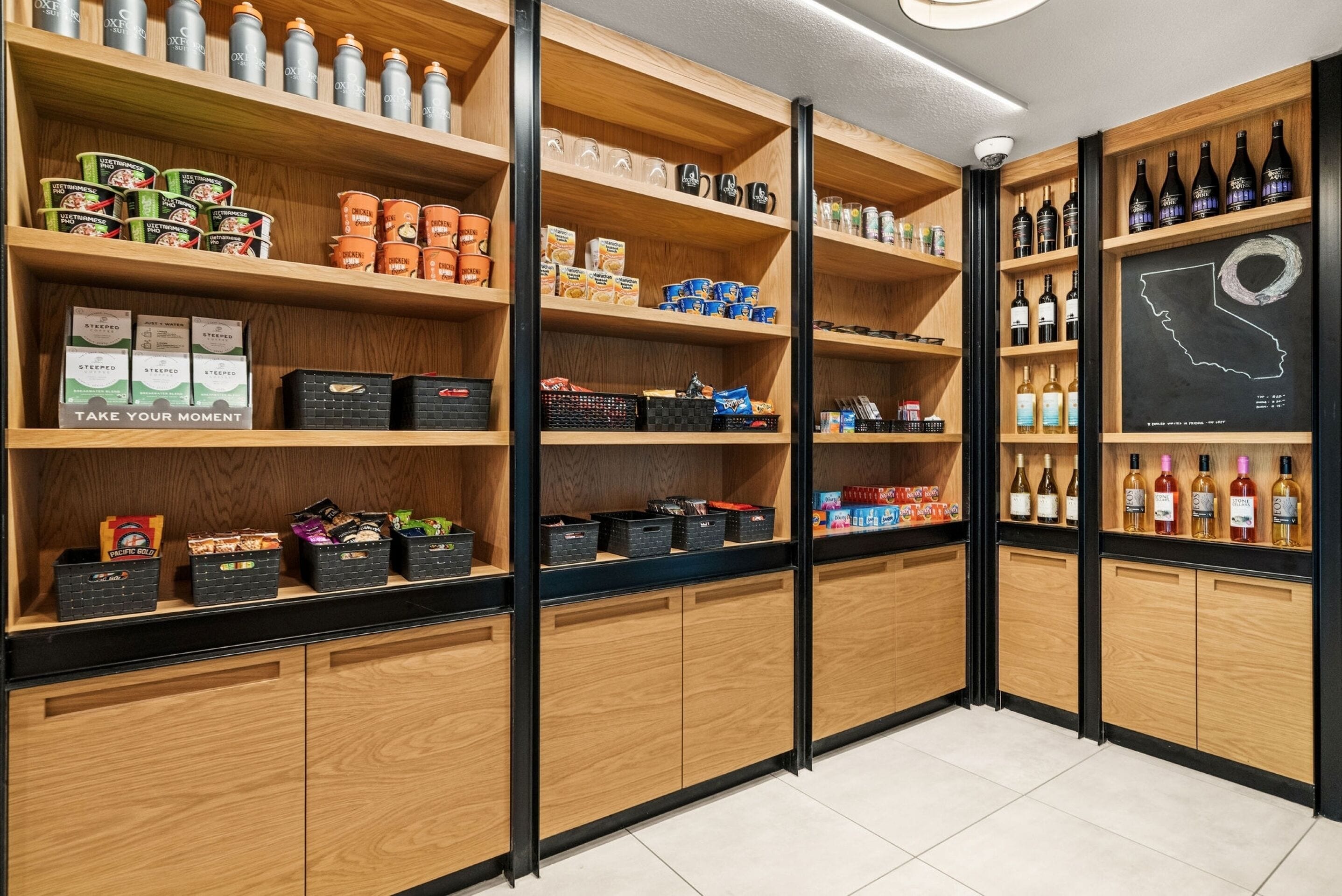 A well-organized retail space with wooden shelves stocked with various products, including beverages and snacks.
