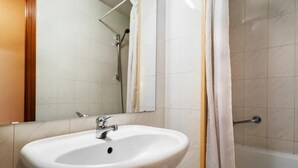 A bathroom with a white sink, a mirror, and a shower area. - Hotel Alcarria (Guadalajara)