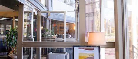 Un espacio de oficina moderno con escritorio, silla y ventanas amplias que ofrecen vistas al exterior.