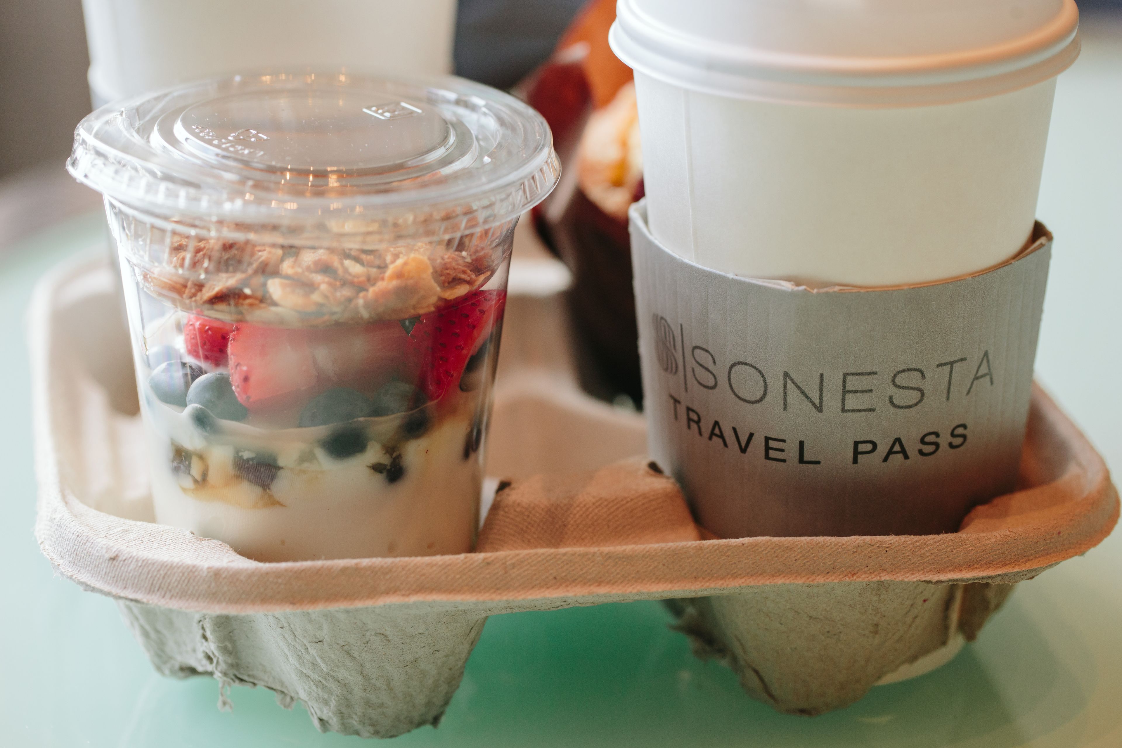 A travel pass and a container with a layered dessert.