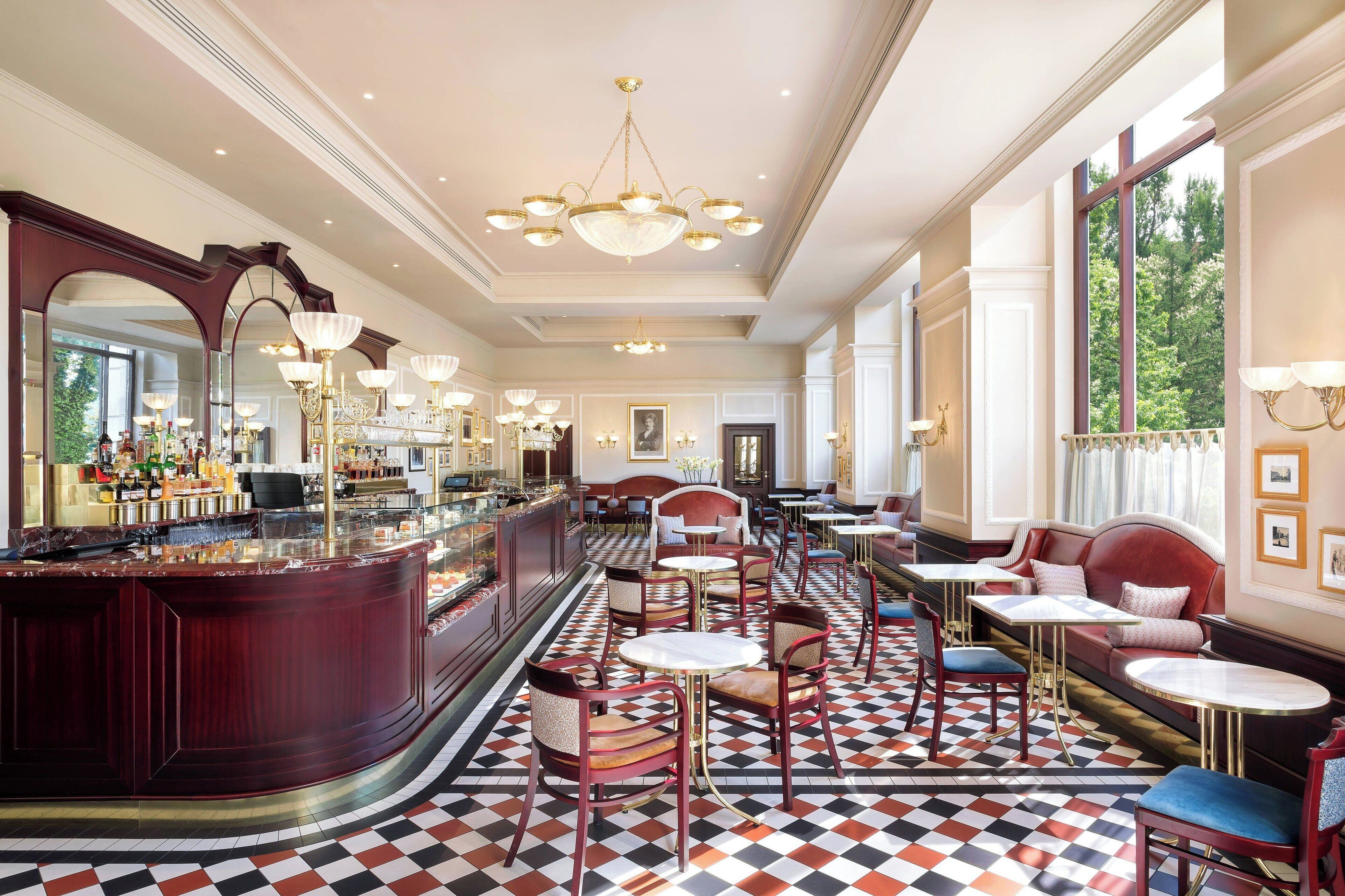 A hotel lobby with a bar, seating areas, and large windows.