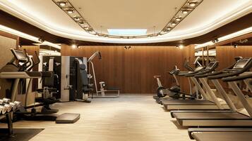 A gym with treadmills, weight machines, and dumbbells.