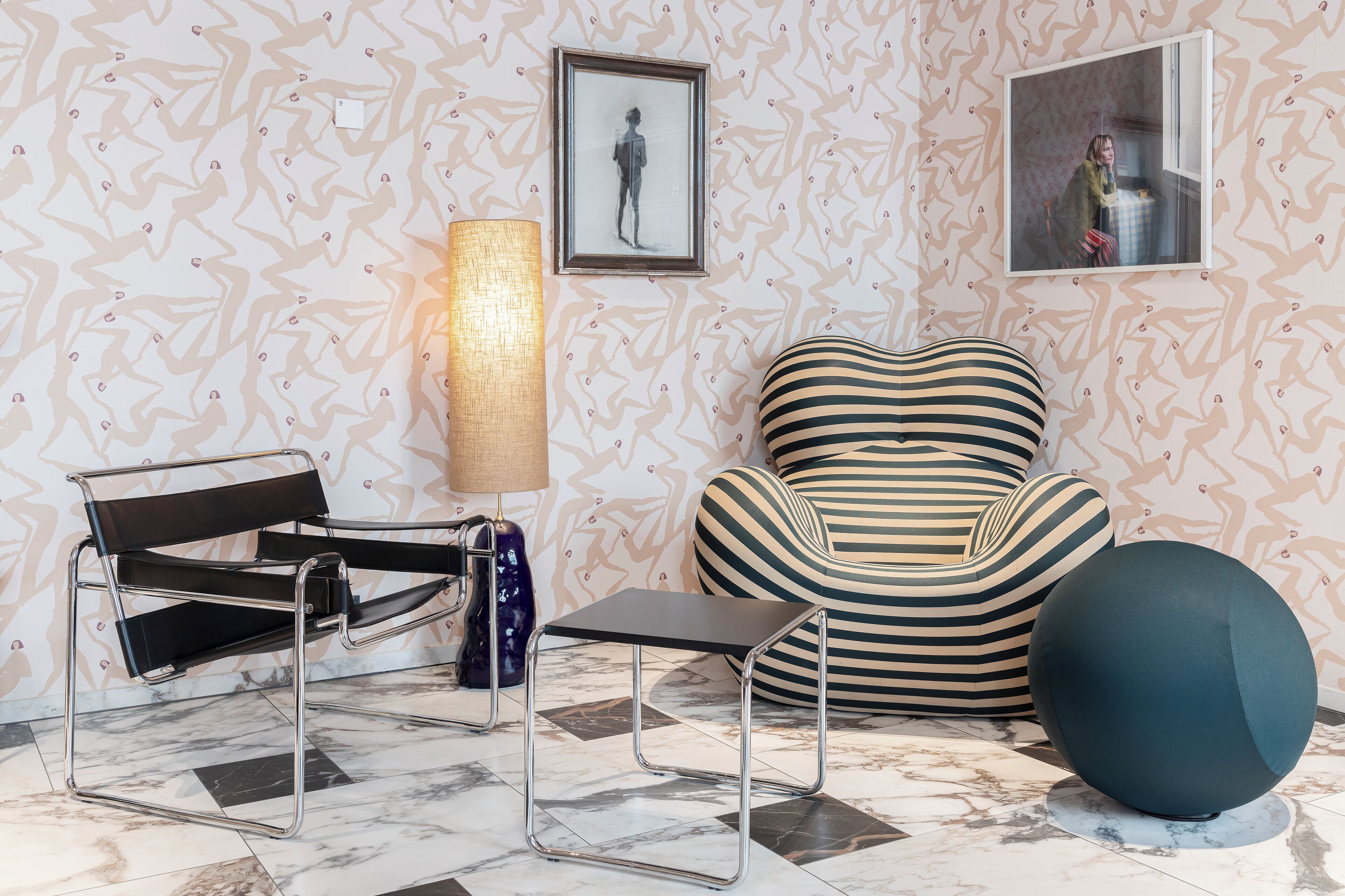 A modern living room with a sofa, a chair, a lamp, and a framed picture on the wall.