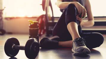 A gym setting with a dumbbell and a water bottle on the floor.