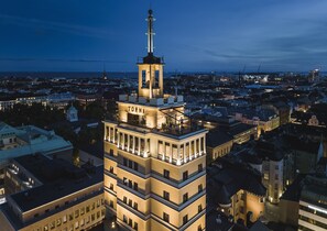 A multi-story hotel with a prominent tower and a balcony on the upper floors.